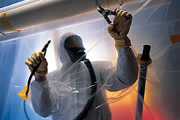 Asbestos Removal: Technician wearing protective gear and removing asbestos.